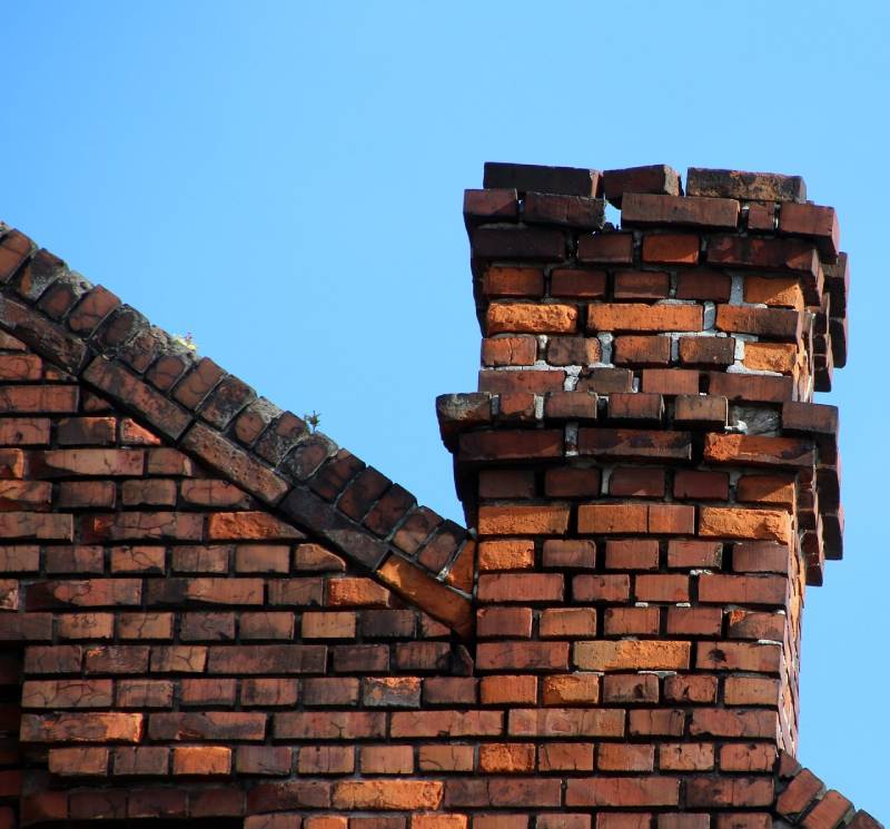 Damaged chimney on an Auburn home showing cracks and missing mortar